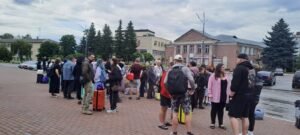 Діти пільгових категорій та дорослі з валізами очікують на відправлення в рамках організованої поїздки на літній відпочинок